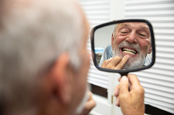 A smiling customer admiring his dental work.